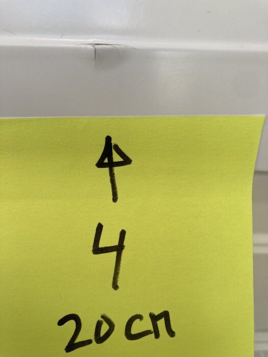 Spricka i lacken på en vit kökslucka från Ikea Metod med en gul post-it som visar mätningar och texten "4" och "20 cm".