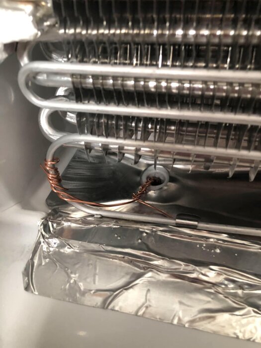 Modifierad frys med koppartråd och aluminiumfolie inuti, visas närbild av rör och komponenter.