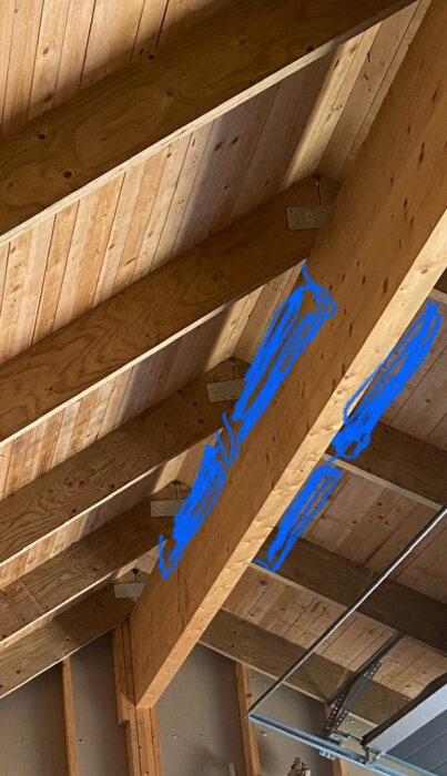 Takbjälkar med två blåmarkerade fack för plast över limträbalk.