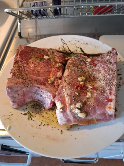 Marinerad fläskkarré på en tallrik, kryddad med vitlök, rosmarin, chili, timjan, salt och peppar.