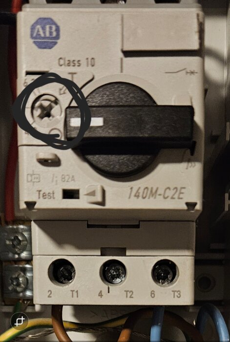 Kretsbrytare med skruv markerad i cirkel, märkt "140M-C2E" och "AB", del av ett fixat problem med brytare och pump.