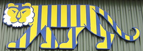 En tiger gestaltad i blått och gult mot en grön ribbad bakgrund.