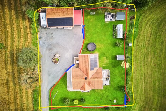 Flygfoto över en trädgård med gräsmatta, träd, växthus, lekstuga och två byggnader. Röd, gul och blå linje markerar olika stängselalternativ.