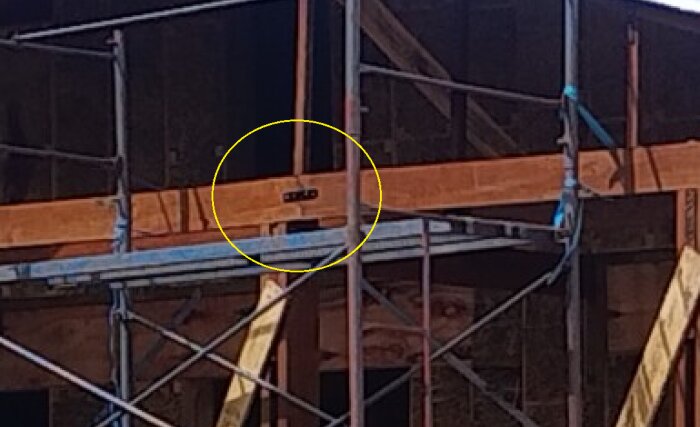 Exterior scaffolding and wooden framework of a building under construction, highlighting inadequate joint support and potential structural instability.