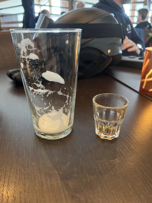 Tomt ölglas bredvid tomt shotglas på ett bord, plats för en konferens.