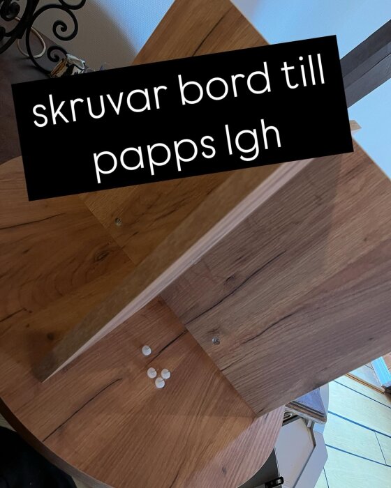 Soffbord av trä sätts ihop, med text "skruvar bord till papps lgh" över bilden. Synliga skruvar och delar på golvet.