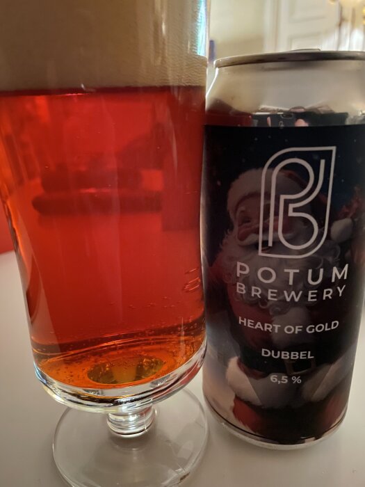Ett glas julöl från Potum Brewery med texten "Heart of Gold Dubbel 6,5%" på burken, bredvid ett halvfullt glas öl.