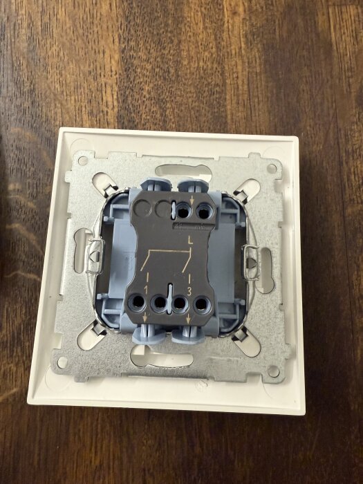 Gammal lamppanelbrytare med tre anslutningar på träbord.