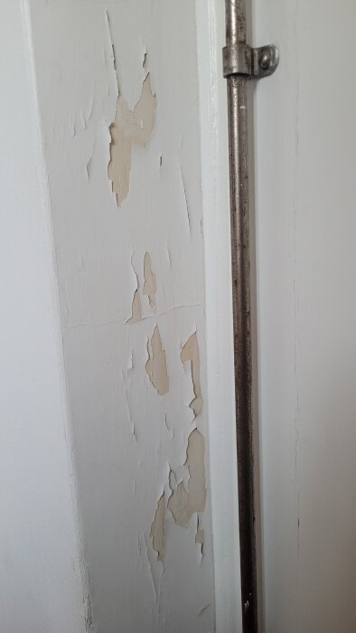 Sprucken och flagnande färg på fönstersmyg i en lägenhet från 1940-talet, eventuellt dåligt grundmålat.