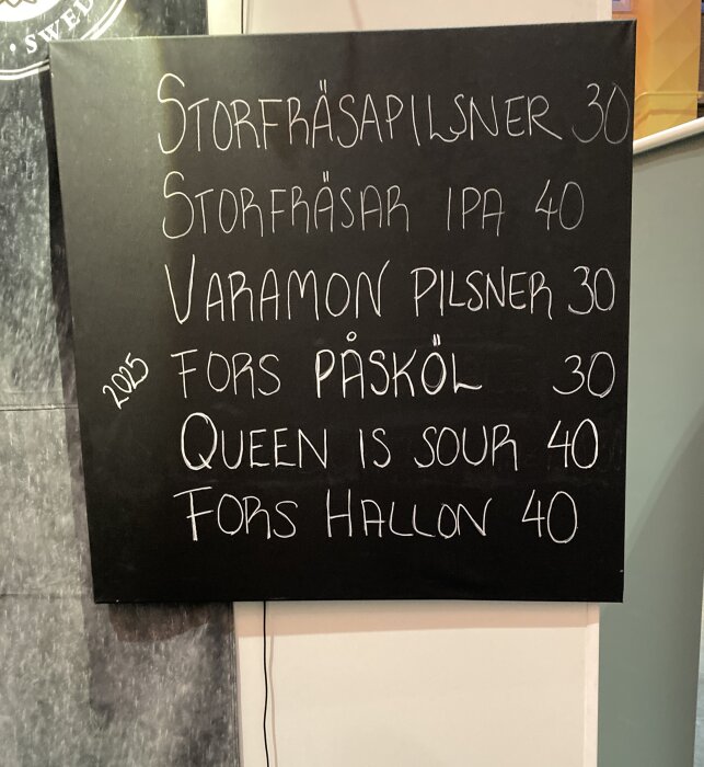 Svart tavla med handskriven lista över öl, inklusive Storfräsarpilsner och Storfräsar IPA med priser mellan 30-40 kronor.