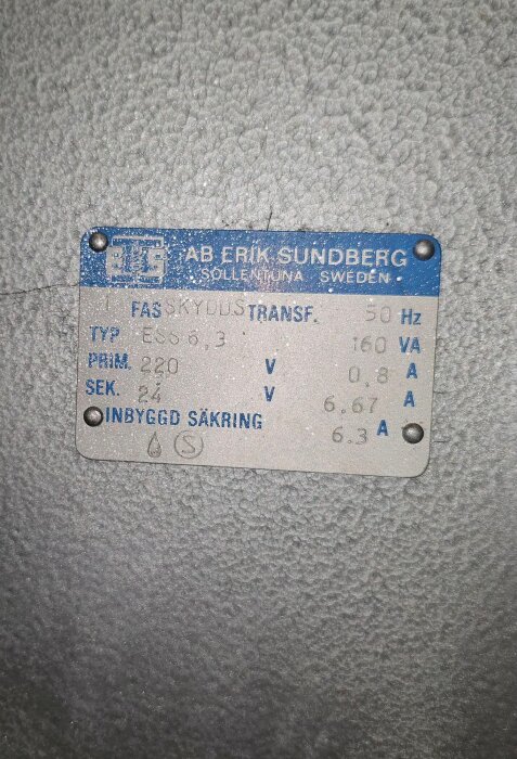 Skylt på en fas skyddstransformator från AB Erik Sundberg, Sollentuna, med specifikationer: primär 220V, sekundär 24V, 50Hz, inbyggd säkring 6.3A.