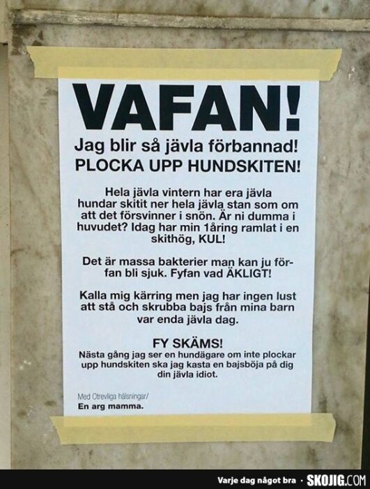 En arg lapp på en vägg där en mamma klagar på hundbajs på gatan och uppmanar hundägare att ta ansvar och plocka upp efter sina hundar.