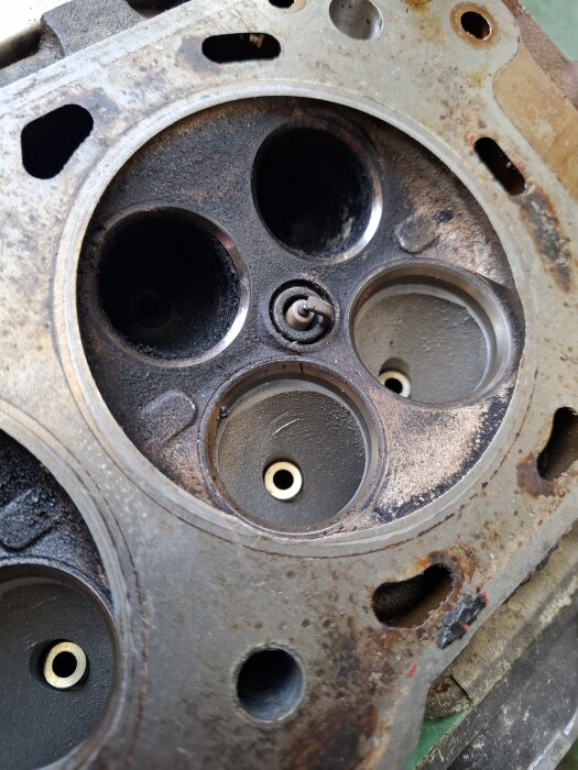 Bild på en motorcylinder med lösa avgasventiler som har tjocka beläggningar och behov av slipning för bättre tätning.
