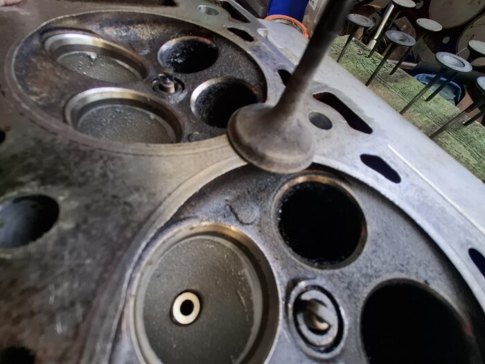 Närbild på en motorcylinder med avgasventiler, vissa med beläggningar. Ventilerna är otäta och kräver underhåll för förbättrad funktion.