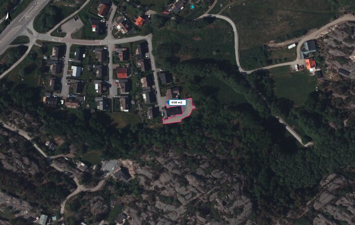 Satellitbild av ett bostadsområde med grönområden och vägar, en markerad tomt på 698 m2 syns i nederdelen av bilden.
