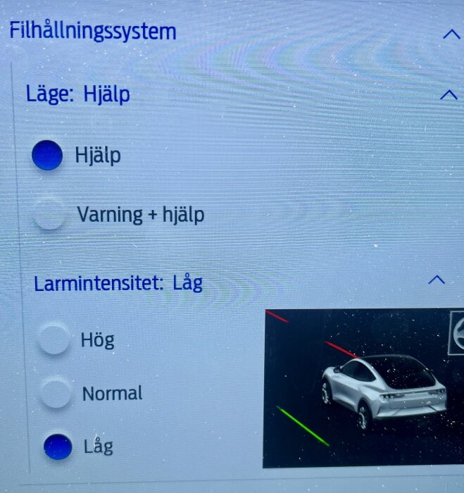 Skärmdump av bilens systeminställningar för filhållning: läge "Hjälp" vald och larmintensitet inställd på "Låg" med bild på bil.