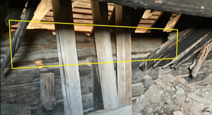 Rottna takbjälkar och förstärkta takstolar, visa skador från läckage och mögel; markerat område indikerar svag punkt i konstruktionen.
