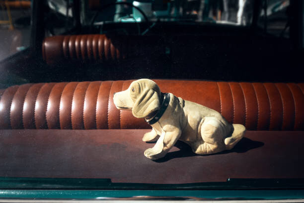 Vintage bilinteriör från 1960-talet med en taxfigur på baksätet.