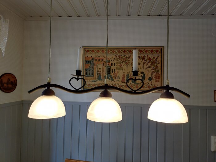 Tre hängande kökslampor över matbord, del av renoveringsfråga om blinkande belysning.