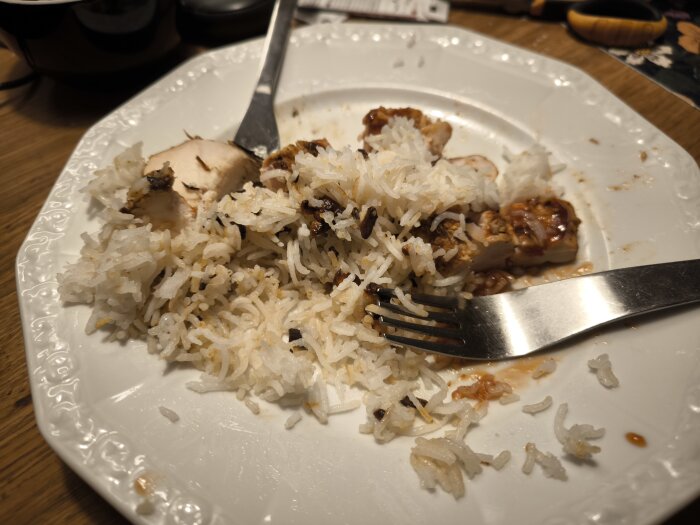 Kycklingfilé och basmatiris med skivad vitlök på en tallrik, serverad med gaffel.