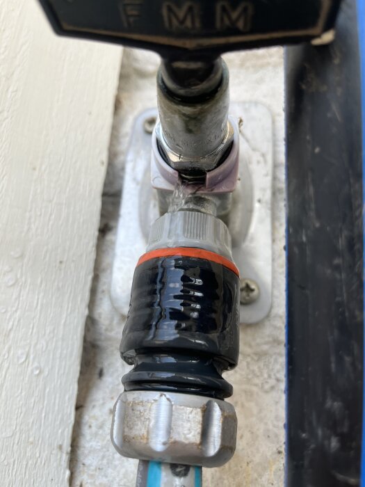 Droppande utomhuskran med vattenläckage vid kopplingen.