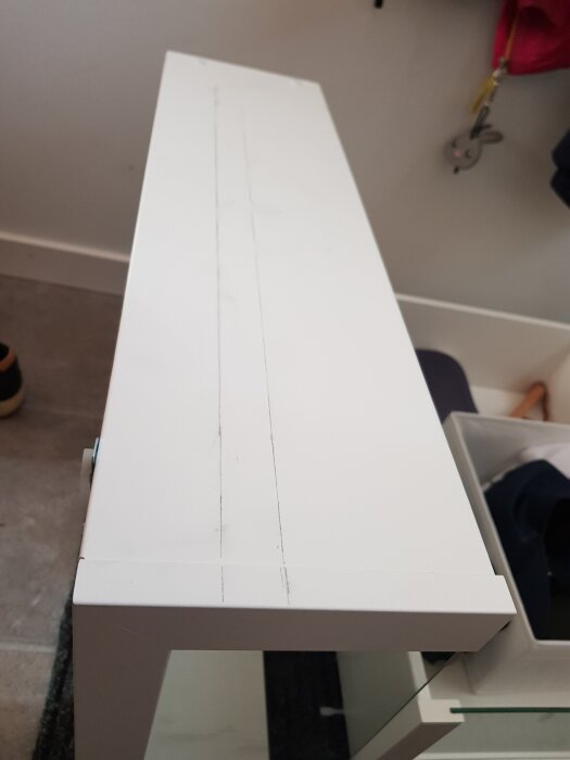 Vit låda med linjer markerade för urfräsning, del av projekt för att använda IKEA-gångjärn.