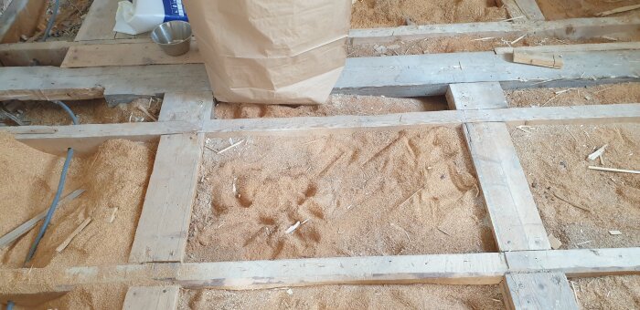 Träbjälklag med sågspån borttaget i golvet på ett hus från 1947, pågående renovering med diskussion om byte till mineralull.