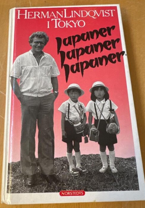 Bokomslag med titeln "Herman Lindqvist i Tokyo" och texten "Japaner, japaner, japaner". Bild på man och två barn i skoluniform.