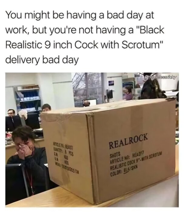 Kartong med texten "REALROCK" och en specifik produktbeskrivning på kontor; person i bakgrunden verkar överraskad.