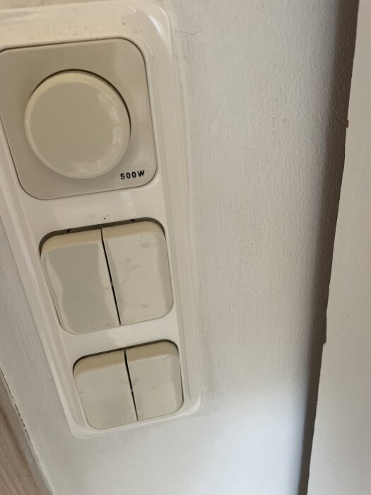 Dimmer och strömbrytare från TREND, 500W, på en vit vägg.