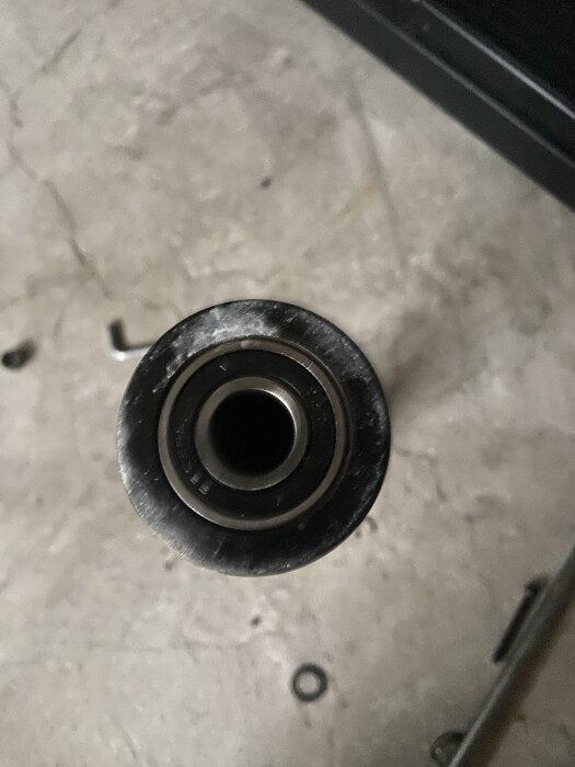 Närbild av ett trasigt kullager på ett löpband, med den yttre delen fortfarande fastsittande.