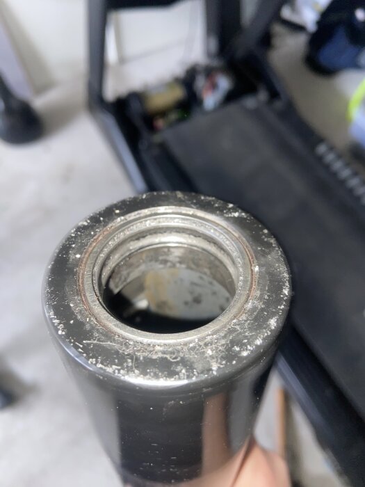 Närbild på ett metallrör med en gängad insida, del av ett bygg- eller renoveringsprojekt.