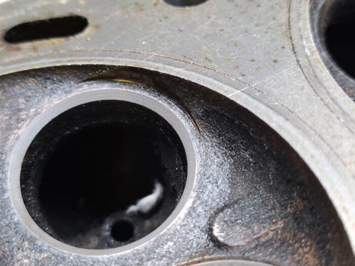 Närbild av en motorcylinderhuvud, detalj av metall med runda öppningar, tagen efter rengöring eller provsmakning.
