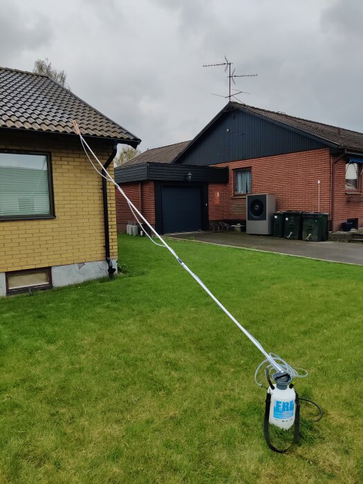 Grönfri medel appliceras på ett tak med hjälp av en spruta och slang, för att rengöra och avlägsna mossa.