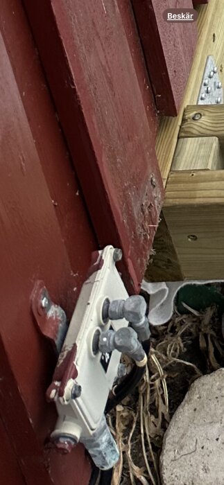 Utanpåliggande apparat med kablar, troligen jordning, monterad på fasad av trä. Kabel går ned mot marken. Huset från 1985.