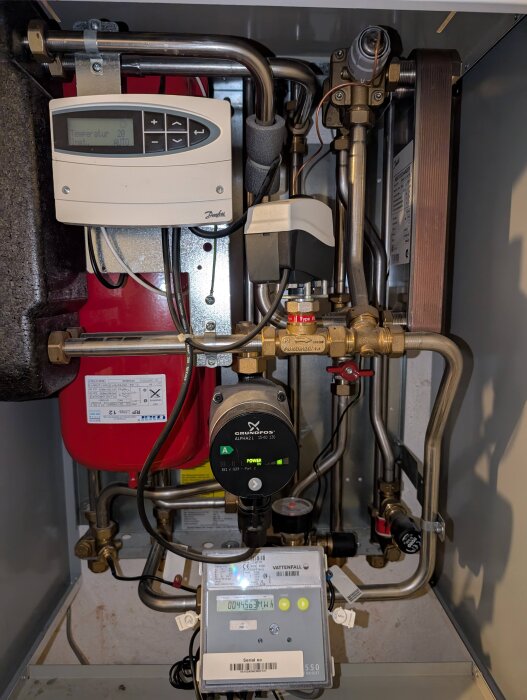 Fjärrvärmecentral med termostat, rörledning, cirkulationspump och mätarutrustning.