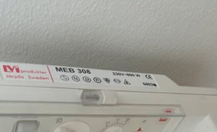 Bild på en MEB 308 enhet märkt med 230V, belägen mot en vit vägg.