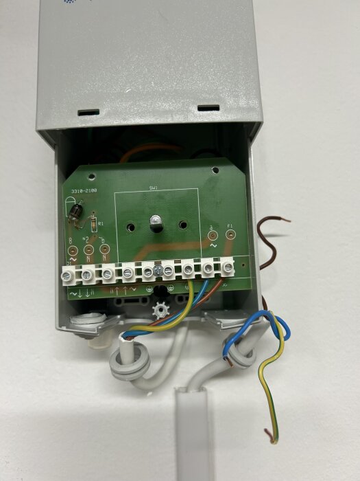 Öppen elbox med kretskort och frånkopplade kablar, synliga anslutningar, utan ström till regulatorn.