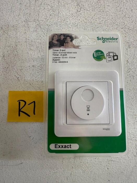 Förpackning med en Schneider Electric tryckknappstimer, 2-polig, justerbar 15 min–8 timmar, på en vit yta med etiketten "R1".