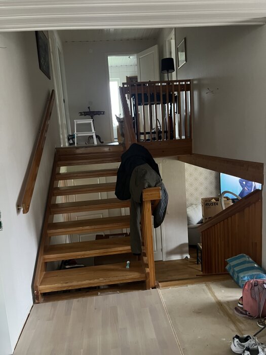 Furutrappa från 1968 i två delar med halvplan, arbetsmaterial och verktyg synliga på och under trappan.