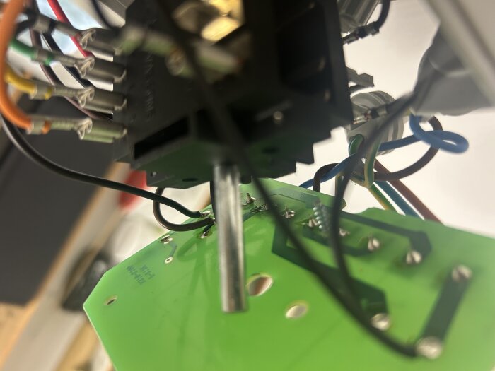 Kretskort med kablar och komponenter i olika färger, fotat ur en vinkel uppifrån.