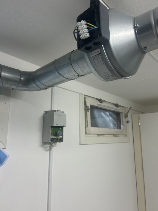 Ventilationssystem med fläkt, sladdar och en trafobelysning som fungerar korrekt installerat i ett rum.