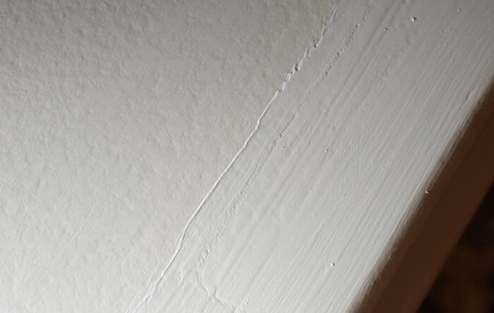 Närbild av vitmålad list som visar skillnad i nyans, diskussion om att hitta en gulare färg pågår.