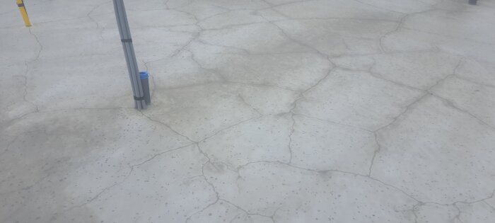 Betongplatta med sprickor och genomföringar, oskyddad gjutning.