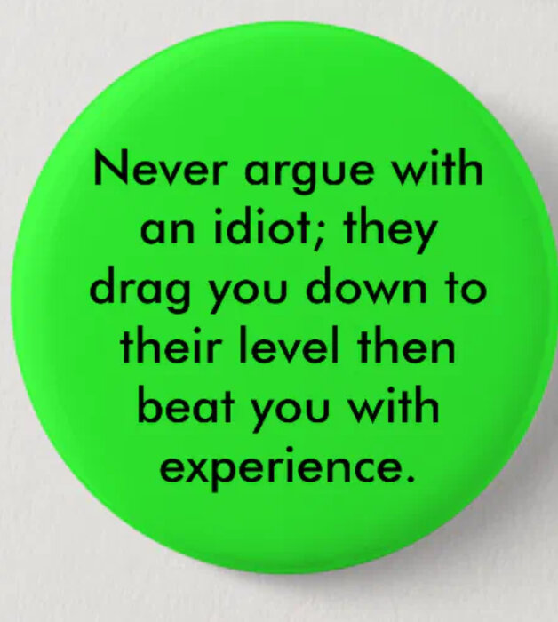 Grön knapp med texten "Never argue with an idiot; they drag you down to their level then beat you with experience.