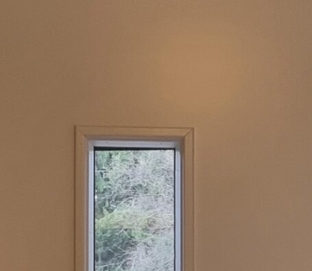 Snett monterat sidoglas i dörrkarm med naturutsikt utanför, del av en diskussion om en felaktig installation.