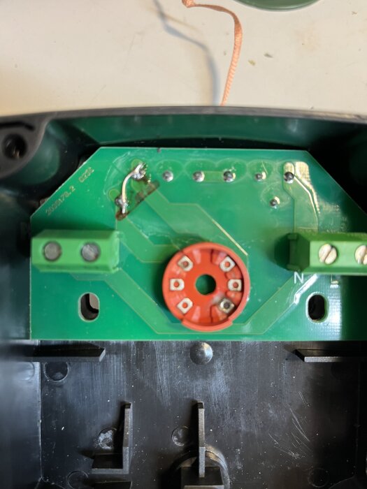 Närbild av en krets och vridesomkopplare till en pump som visar lödningar och kopplingar i en maskin.