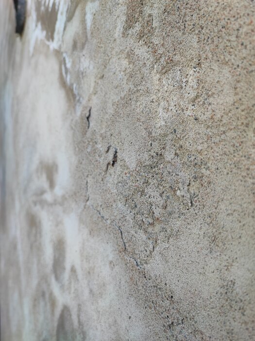 Närbild på en trappa med ytliga sprickor och missfärgningar, troligtvis orsakade av saltutfällning.