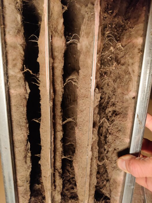 Smutsigt tilluftsfilter från ventilationsaggregat visat efter ett års användning. Filterlamellerna är täckta av damm och smuts.