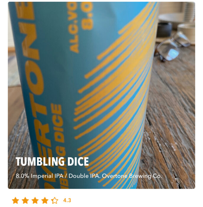 Flaska med etikett "Tumbling Dice", 8.0% Imperial IPA från Overtone Brewing Co. på ett träbord.